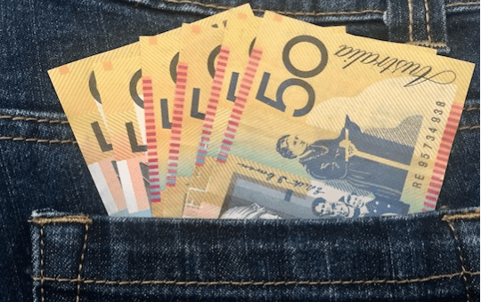 A collection of $50 australian notes in someones back pocket